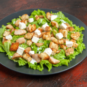 bottom-view-caesar-salad-oval-plate-dark-red-table