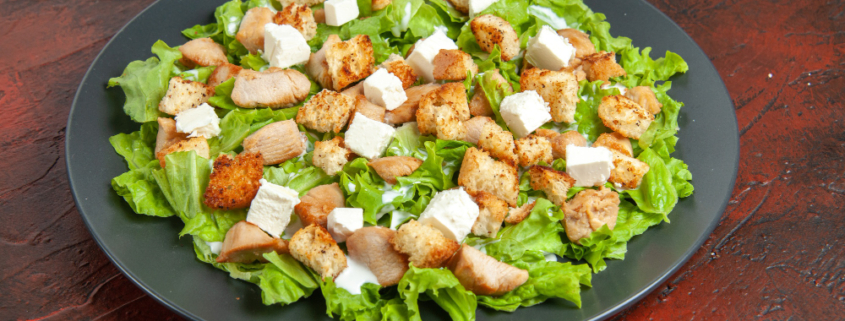 bottom-view-caesar-salad-oval-plate-dark-red-table